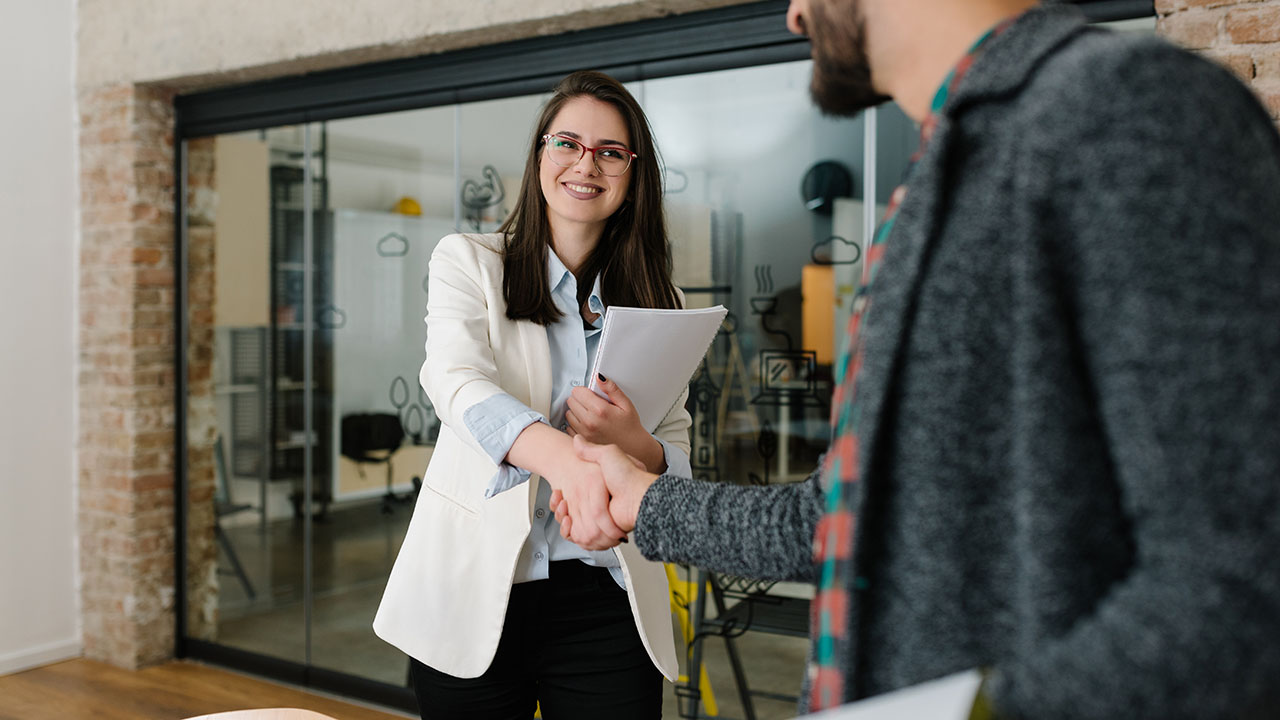 Coworkers shaking hands in a modern office