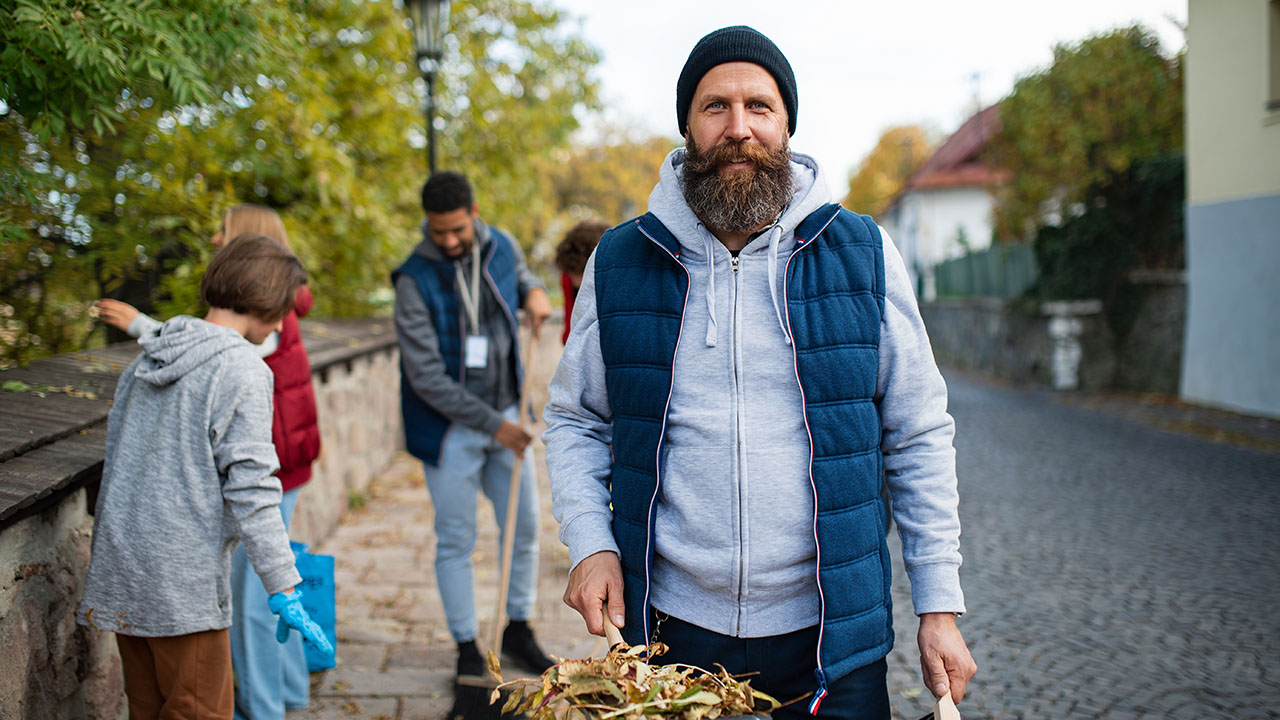 Man helping clean up outdoors for a nonprofit