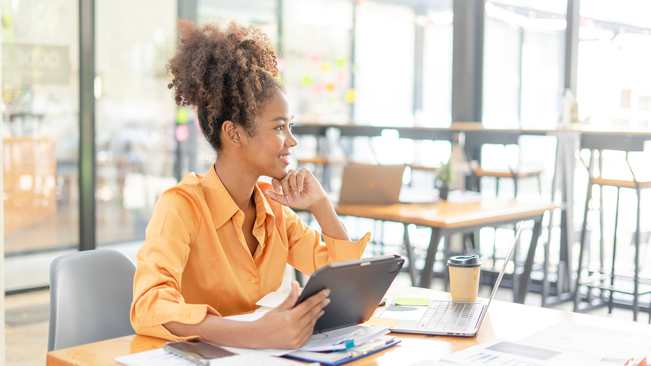 Female in orange shirt working on a tablet